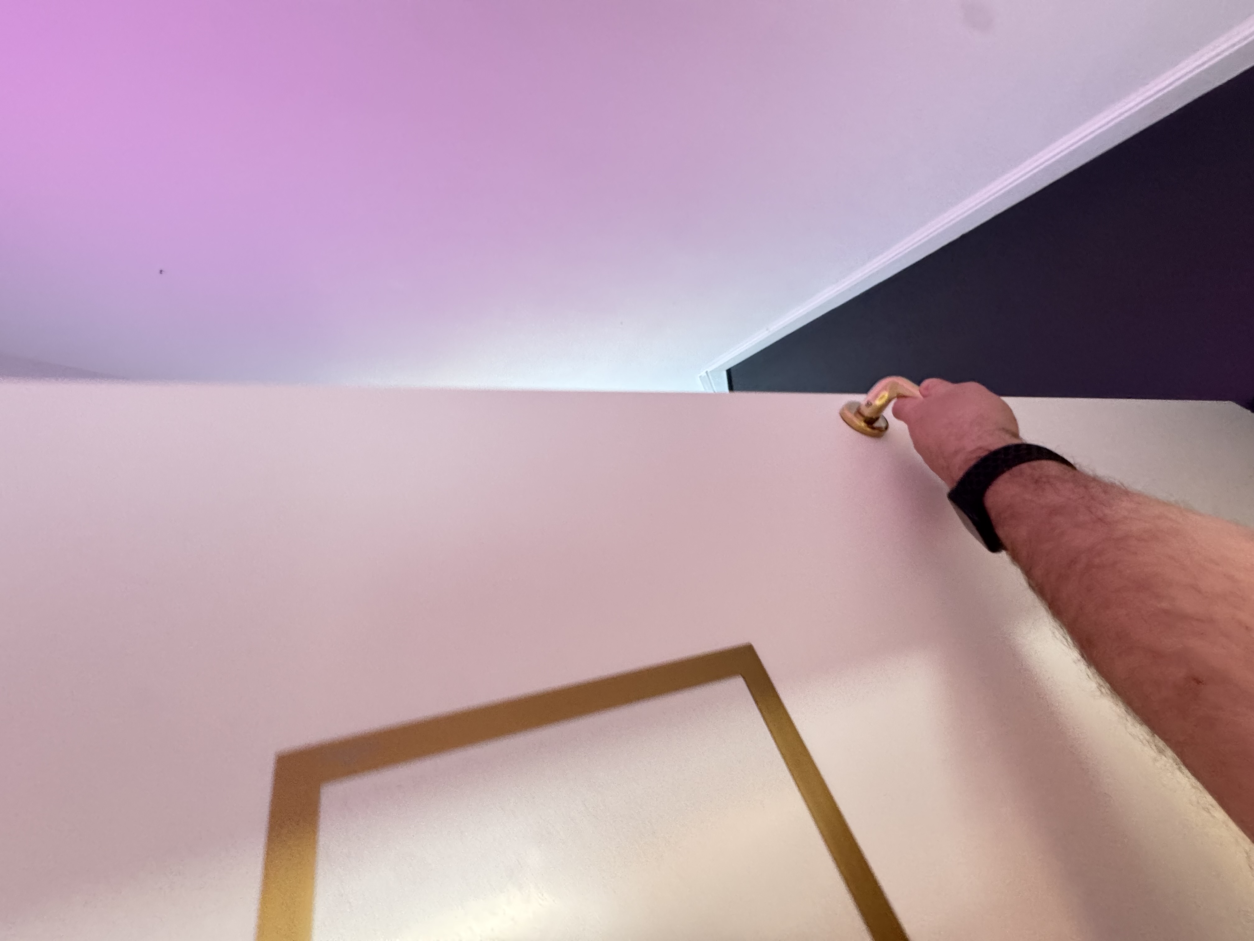 Hand opening the apartment door from inside, brass thumb-turn handle.