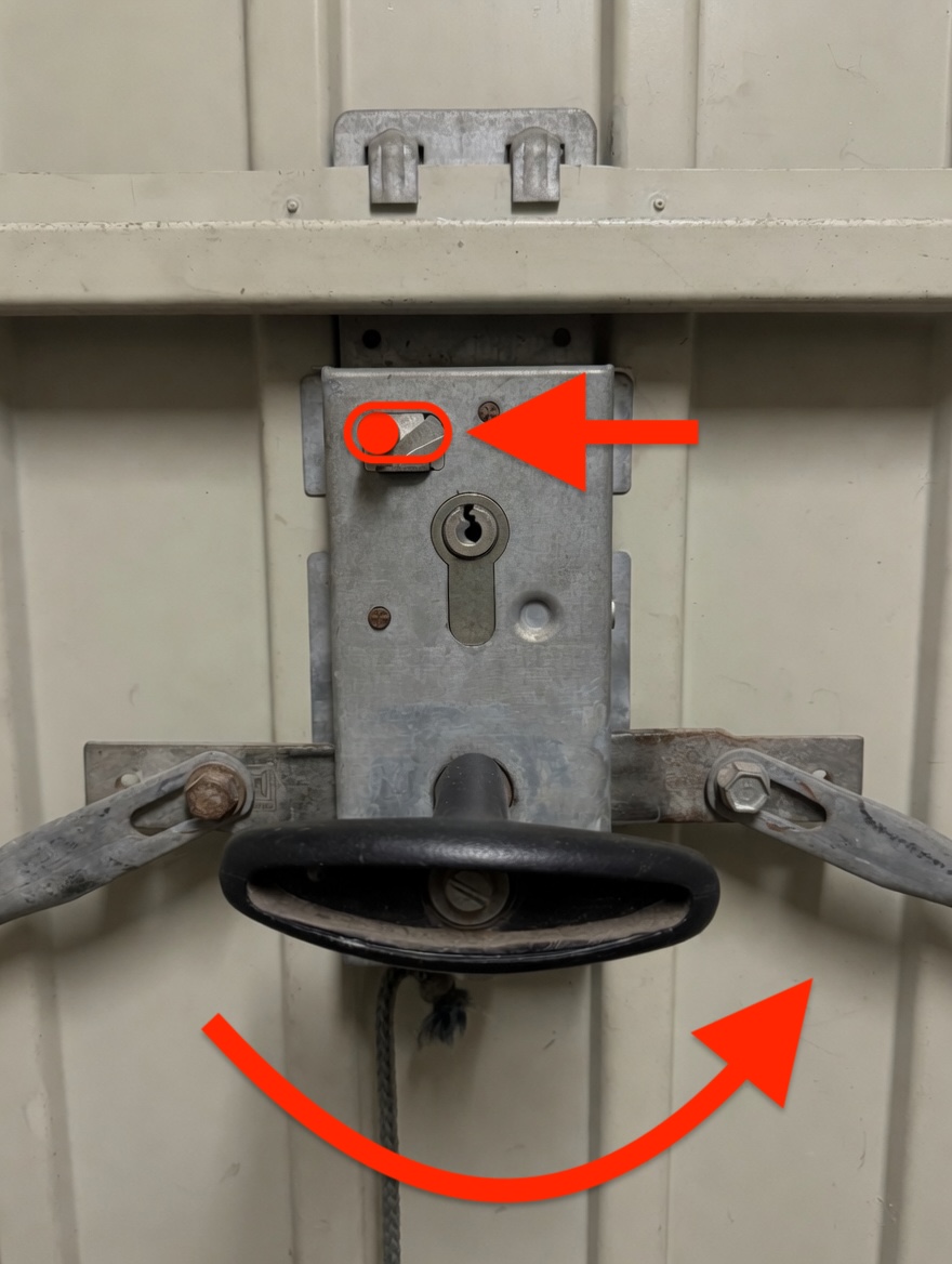 Close-up of the thumb-turn cylinder lock on the inside of the garage door.